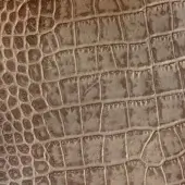 Printed leather texture with a repetitive crocodile scale pattern in varied brown tones, featuring raised rectangles and etched lines.
